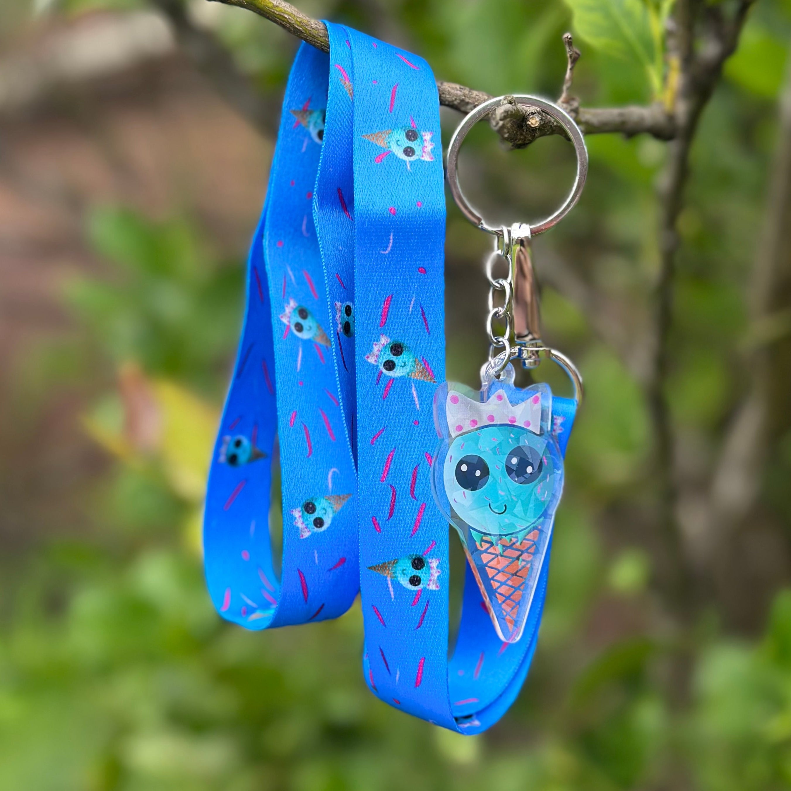 A blue bubblegum Ice Cream wearing a silver crown accompanies by a long blue necklanyard with pink sprinkles and repeat bubblegum Ice Cream Print