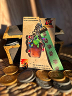 Cattle Dog Pot Plant Flash Holographic Acrylic Keychain, with a green kanyard that has paw prints on it. Taken in front of a Pirate Chest