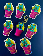 Frankie the French Bulldog in French Fries Acrylic Keychain stacked by some holographic Stickers of Frankie Blue Background