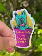 "DId somebody say french fries?" Text over a french fries packet with fries and a blue frenhc bulldog sitting in side holographic sticker. Taken Outdoors