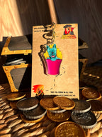 Blue French Bulldog sitting in a Pink French Fries Packet Acrylic Keychain surrounded by treasure