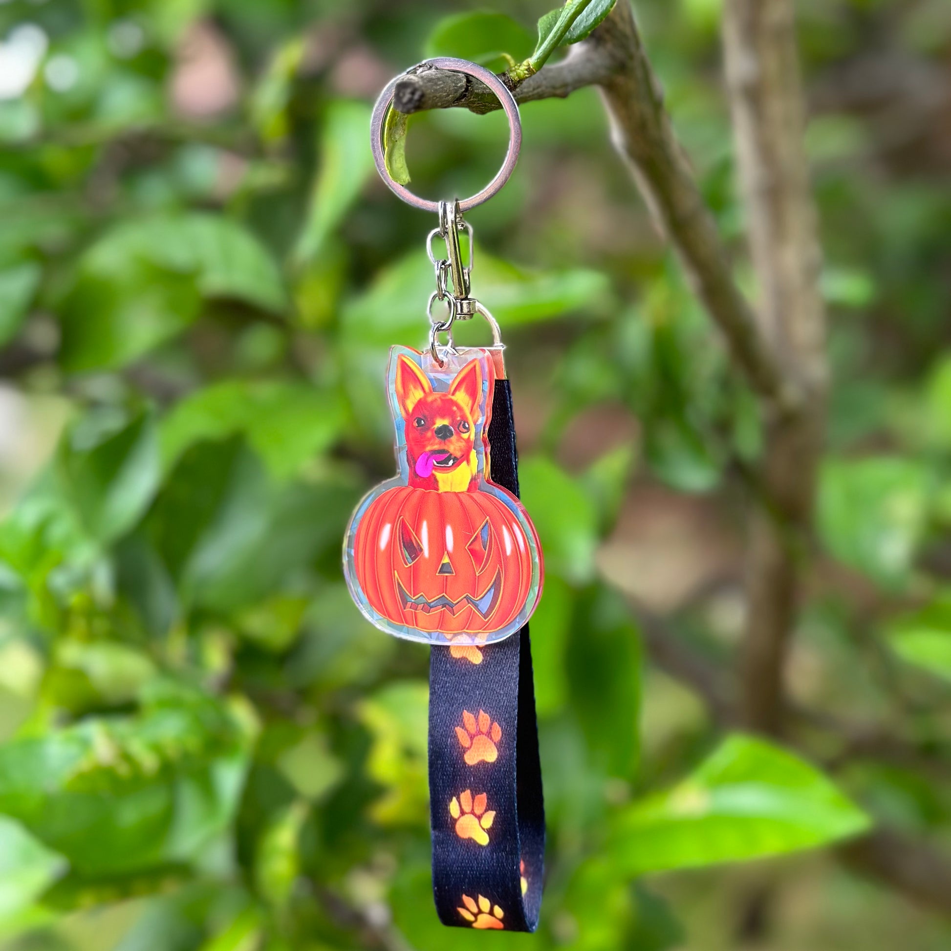 Fiery Chihuahua in a Pumpkin for Halloween Acrylic Holographic Keychain with a black lanyard and glowing orange paws 