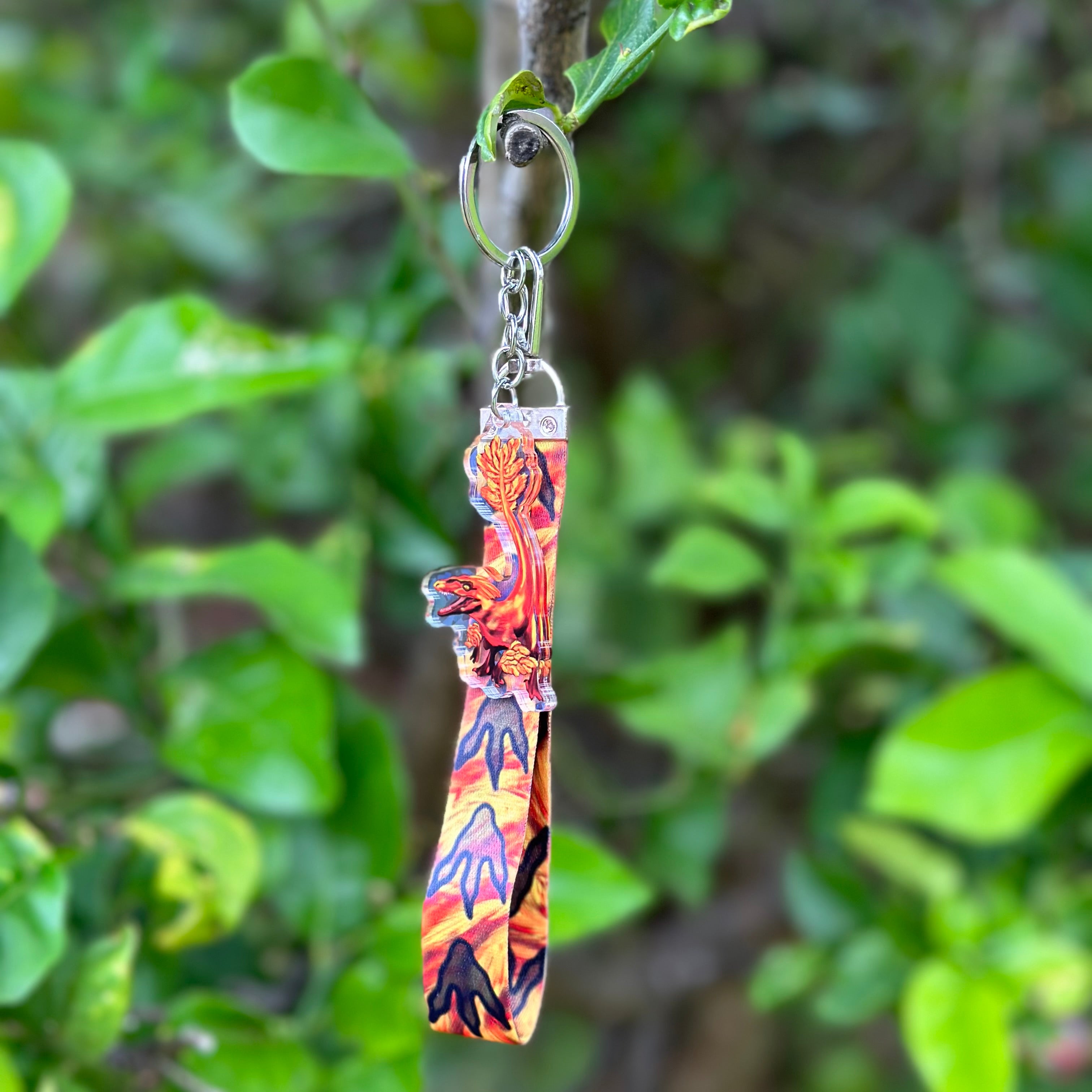 Red fiery Pyroraptor Dinosaur Acrylic Holographic Keychain with a fiery lanyard that has dinosaur paws Lanyard