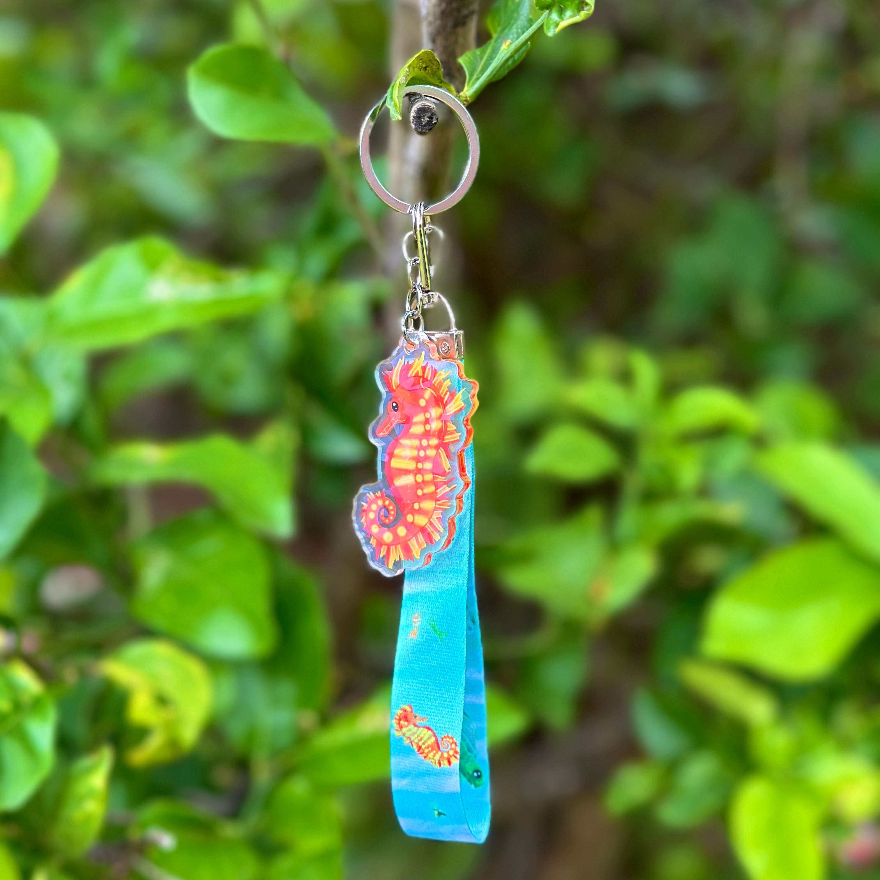 Fiery coloured Seahorse Acrylic Holographic Keychain with a blue lanyard that features sea creatures such as turtles, seahorses and fish!