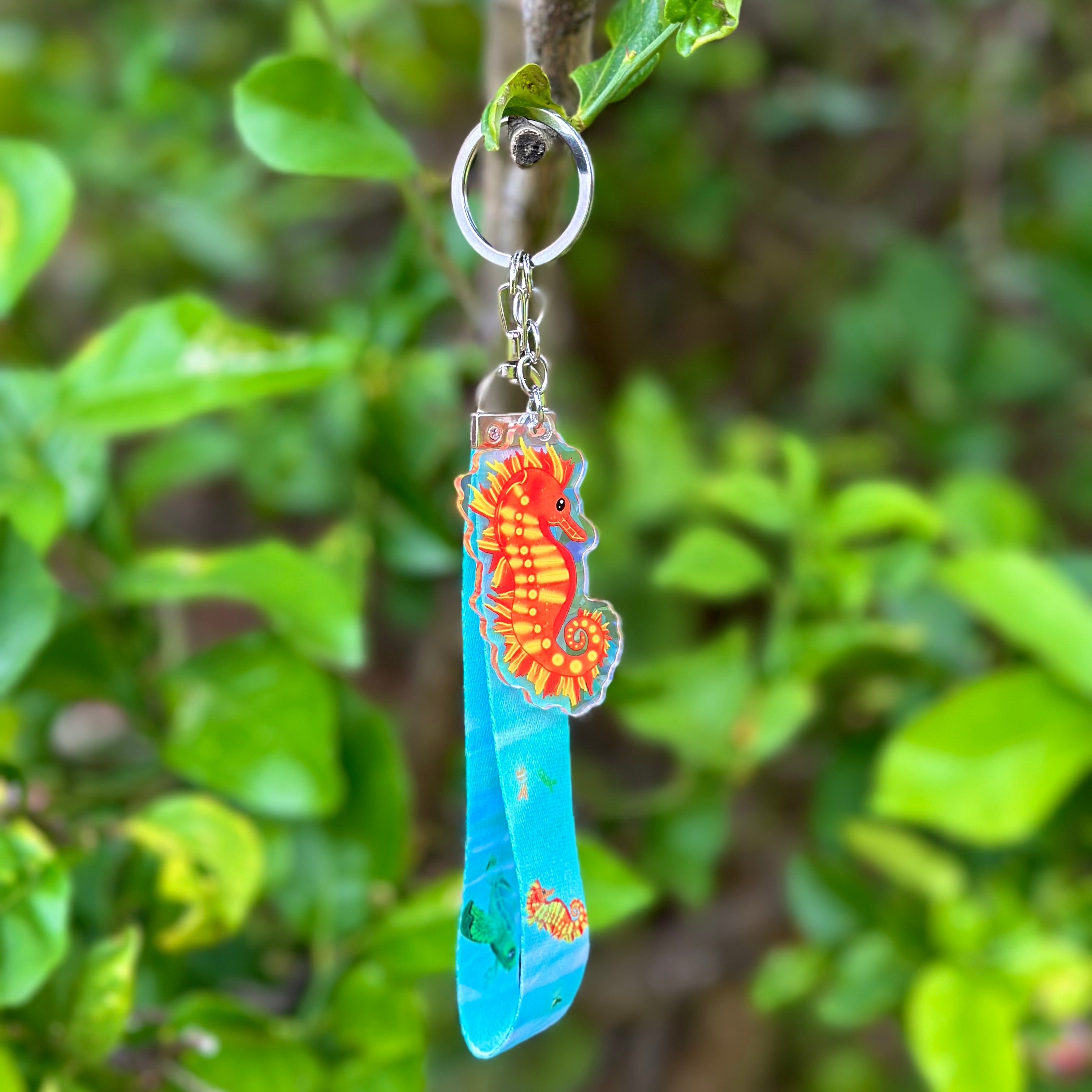 Fiery coloured Seahorse Acrylic Holographic Keychain with a blue lanyard that features sea creatures such as turtles, seahorses and fish!