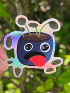 Thirsty Pot Plant Holographic Sticker taken outdoors